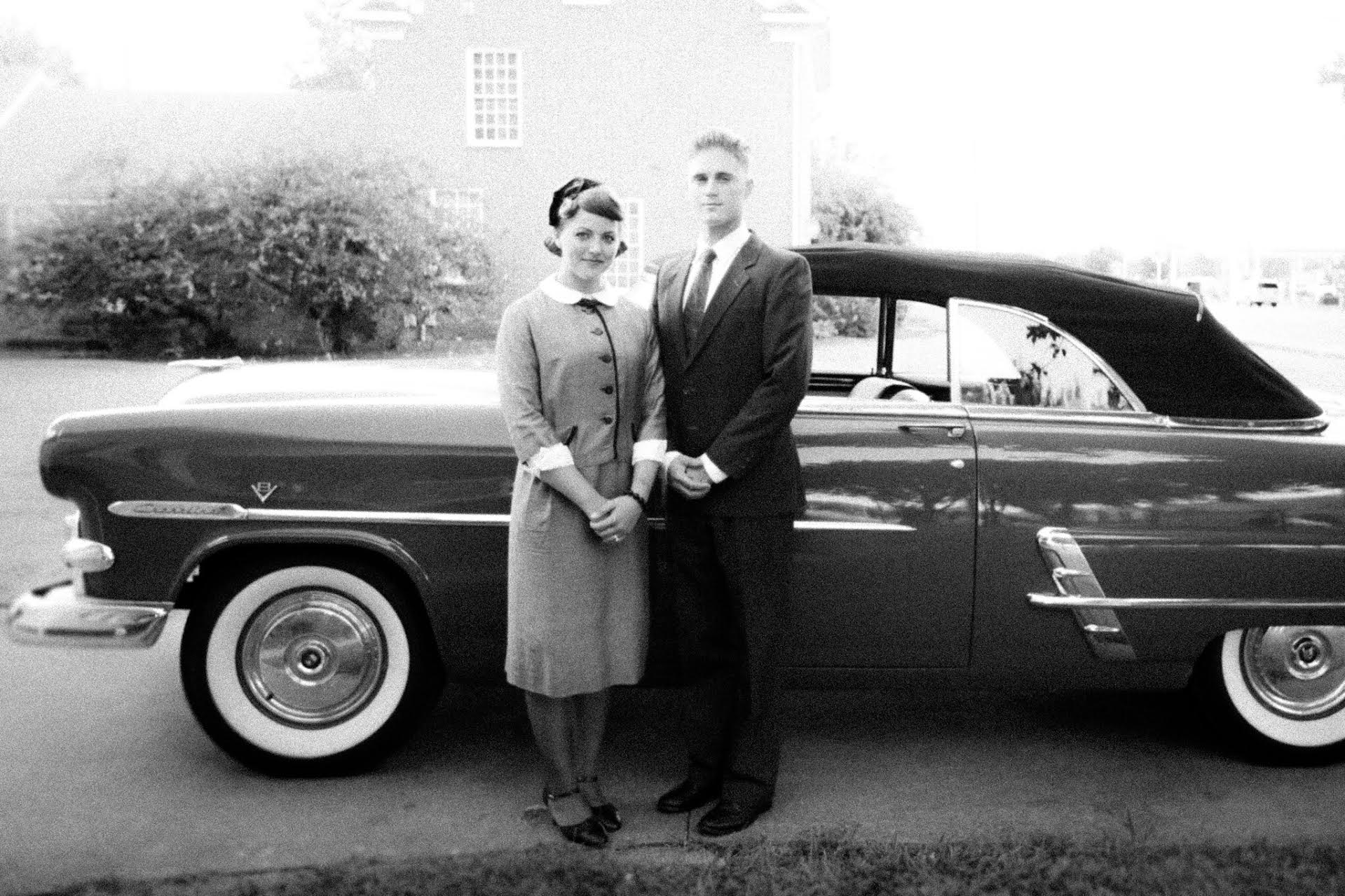 old photo of couple in front of car